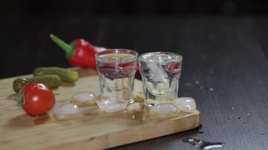 Rustik tahtadaki bardaklarda votka. Buz küpleri ekleme.