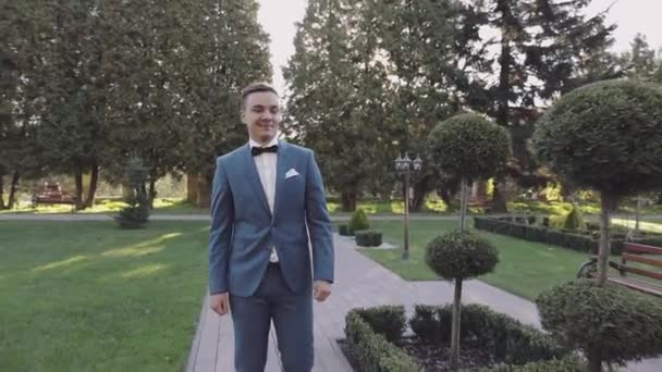 Parkta yürüyen yakışıklı damat. Bakımlı adam. Düğün günü — Stok video