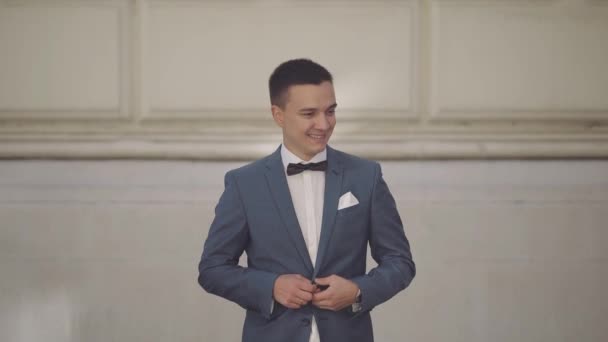 Schöner Bräutigam fixiert seine Jacke. Hochzeitstag. Zeitlupe — Stockvideo