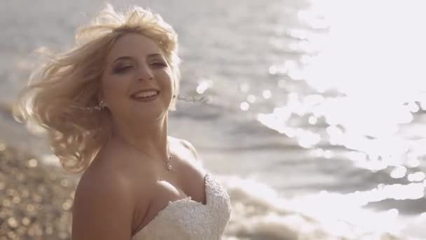 Linda e adorável noiva caminhando ao longo da costa do mar — Vídeo de Stock