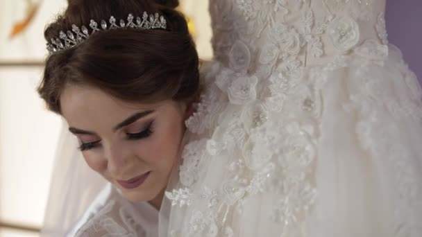 Belle et belle mariée en robe de nuit se tient près de robe de mariée. mariage — Video