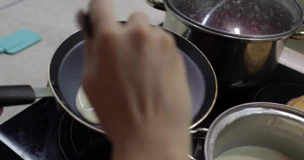 El proceso de cocinar panqueques caseros. Mujer vierte masa de panqueque en la sartén — Vídeos de Stock