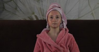 TV 'de gece yarısı film izleyen, elma yiyen bir kadın. Bornoz, yüz maskesi.