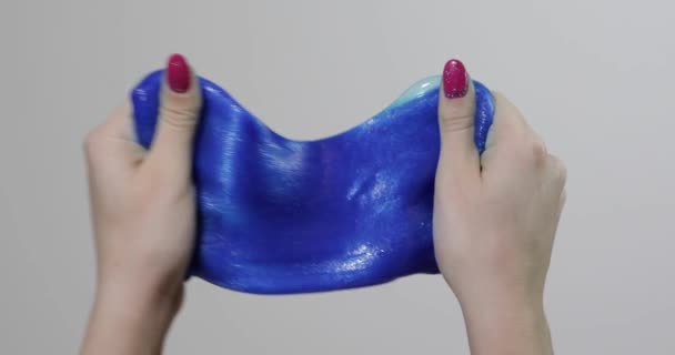 Woman hands playing with oddly satisfying blue slime gooey substance. Antistress — Stock Video