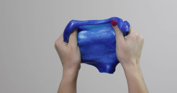 Woman hands playing with oddly satisfying blue slime gooey substance. Antistress — Stock Video