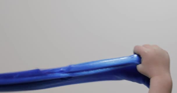 Kinderhände, die mit seltsam befriedigender blauer Schleimsubstanz spielen. Antistress — Stockvideo