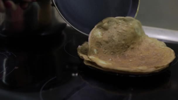 Processen för Matlagning hemlagad pannkakor. Kvinna sätter pannkaka från pannan till plattan — Stockvideo