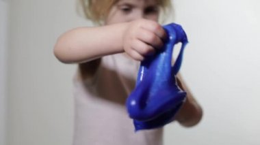 Çocuk balçık yaparken eğleniyor. El yapımı oyuncak balçıkile oynayan çocuk.