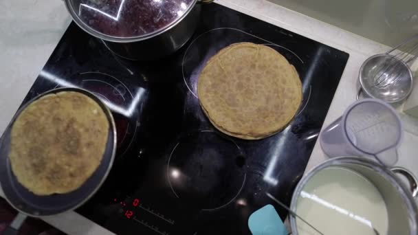 Der Prozess des Kochens hausgemachter Pfannkuchen. Frau legt Pfannkuchen aus Pfanne auf Teller — Stockvideo