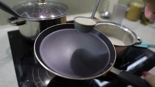 A folyamat a főzés házi palacsintát. Nő önti palacsinta tésztát serpenyőben — Stock videók