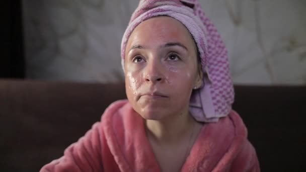 Mujer viendo una película nocturna en la televisión, comiendo palomitas de maíz. Albornoz, máscara facial — Vídeos de Stock