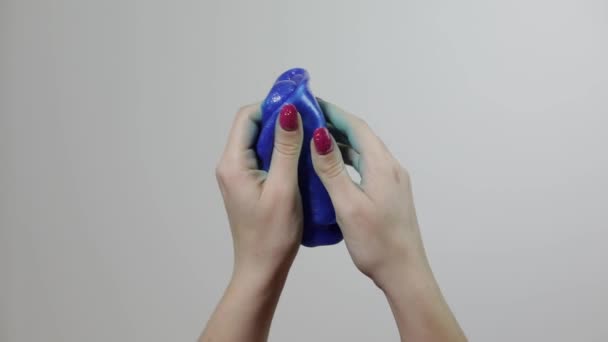 Mani donna giocando con stranamente soddisfacente sostanza appiccicosa melma blu. Antistress — Video Stock