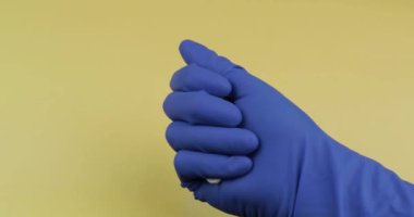 Elinde kauçuk steril tıbbi eldiven giymiş beyaz hapları büyük miktarda