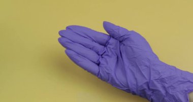 El mavi tıbbi eldiven giymiş diğer eline iki beyaz oval hap koyar