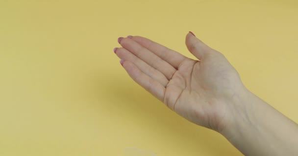 Arts hand gekleed in blauwe medische handschoen zet een witte pil in vrouw hand — Stockvideo