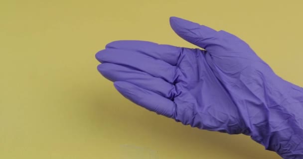 Рука в синей медицинской перчатке кладет одну овальную белую таблетку в другую руку — стоковое видео