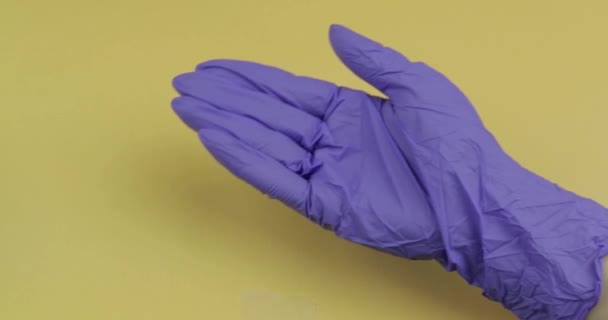 Hand dressed in blue medical glove puts two white pill into other hand — Stock Video