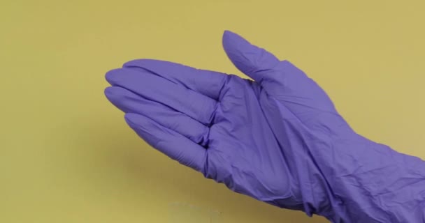 Mão vestida de luva médica azul coloca dois comprimidos redondos brancos em outra mão — Vídeo de Stock