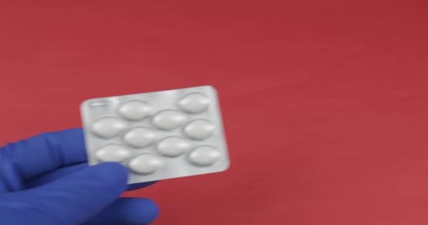 Doctor hand in medische handschoen geeft blister met pillen en ontvangen contante betaling — Stockvideo
