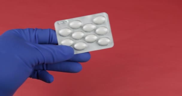 Врач рука в медицинской перчатке дает волдырь с таблетками и получить наличный расчет — стоковое видео