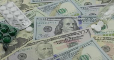 Dolar banknotları üzerine düşen haplar, pahalı ilaçlar, ilaç işi.