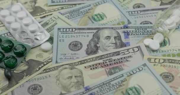 Таблетки, що падають на доларові банкноти, дорогі ліки, фармацевтичний бізнес — стокове відео