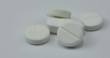 Beyaz yuvarlak haplar ve ilaçlar dönüyor. Haplar ve tabletler dönüyor. Makro çekimi