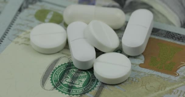 Медицинские таблетки и таблетки на долларовой купюре. Концепция фармацевтического бизнеса — стоковое видео