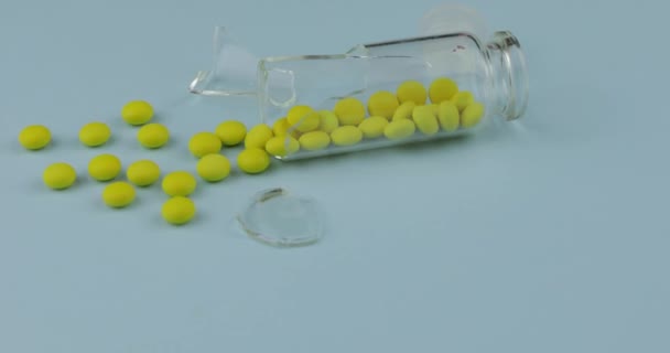 Glasscherben mit vielen Pillen und Drogen auf blauem Hintergrund