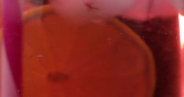 Buz ve kireç ile bir bardak serinletici bir kırmızı içecek kokteyl yapma