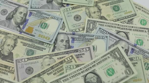Dolarové bankovky padají na stůl s americkými dolary různých denominací — Stock video