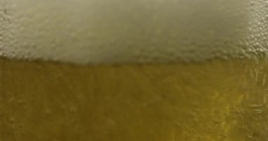 Bir bardağa soğuk altın ışıklı bira dökmek. Zanaat bira kabarcıklar ve köpük yapma