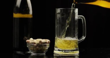 Şişeden bir bardağa Soğuk Işık Birası dökmek. Craft Bira yakın çekim