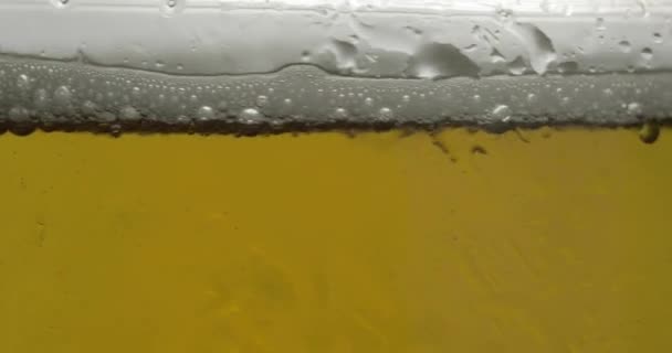 グラスに冷たい軽いビール。クラフトビールクローズアップマクロ。回転360度 — ストック動画
