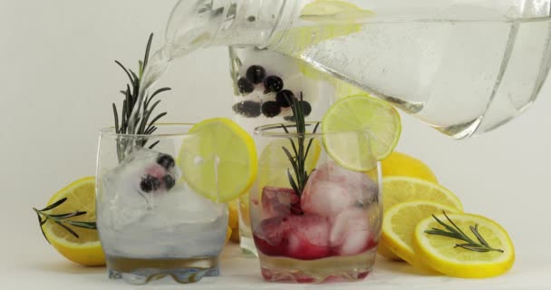 In Trinkgläser ein kaltes Getränk einschenken. Herstellung von Soda roten und blauen Cocktails — Stockvideo