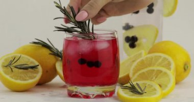 Limon dilimi, biberiye, soda limonata kırmızı kokteyl ile bir bardak saman ekleme