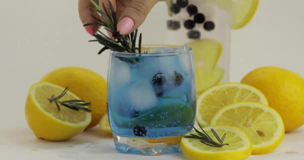 Añadir rodaja de limón, romero en un vaso con refresco de limonada cóctel azul — Vídeos de Stock