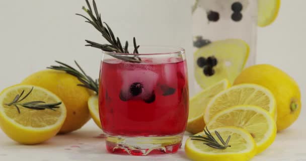 Adding lemon slice, rosemary, straw in a glass with soda lemonade red cocktail