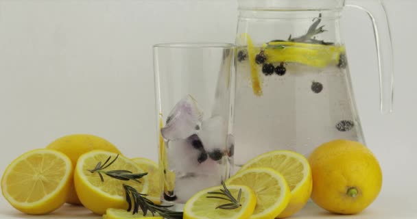 Wlać zimny napój gazowany. Cytryna i lód w szklance napoju. Orzeźwiający koktajl — Wideo stockowe