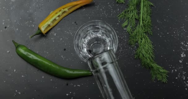 Giet alcohol drinken wodka uit een fles in shot Glass. Oppervlak met snacks — Stockvideo