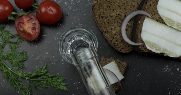 Häll alkohol dricka vodka från en flaska i snapsglas. Yta med tilltugg — Stockvideo