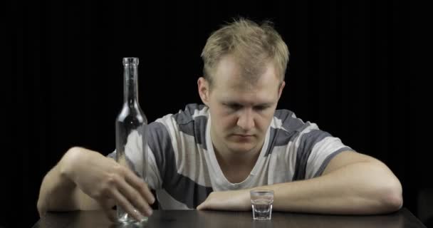 Deprimerad man dricker vodka ensam i ett mörkt rum. Begreppet alkoholism — Stockvideo