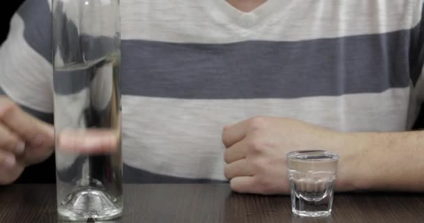 Hombre deprimido bebiendo vodka solo en una habitación oscura. Concepto de alcoholismo — Vídeo de stock