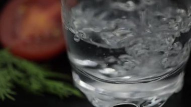 Bardak bir şişeden alkol içecek votka dökün. Aperatifler ile yüzey