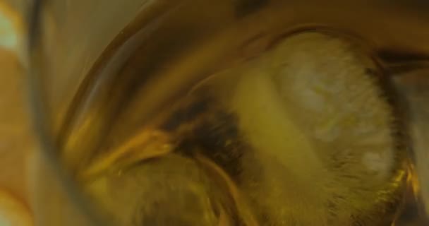 Whiskey with ice cubes in drinking glass. Glass of rum alcohol — Stock Video