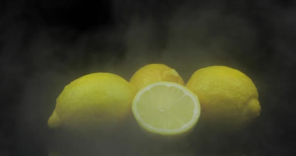 Fruta tropical limón en hielo frío nubes de humo de niebla sobre fondo negro — Vídeo de stock