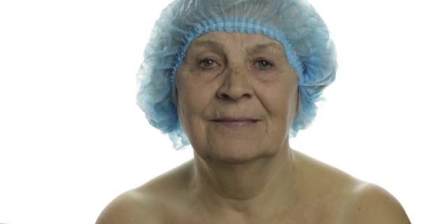 Mujer anciana sonriente con sombrero protector asustada de la jeringa con medicamentos — Vídeo de stock