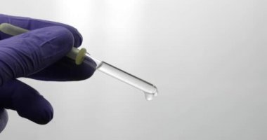 El tıbbi eldiven damla pipet. Yakın çekim video. Sıvı damla