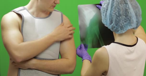 Hombre con lesión en el hombro. La enfermera examina los rayos X. Vendaje para la fijación del hombro — Vídeo de stock