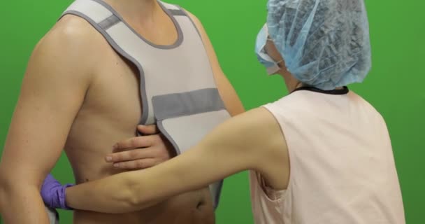 Mann mit Schulterverletzung. Krankenschwester trägt zum Patienten einen Verband zur Fixierung der Schulter — Stockvideo